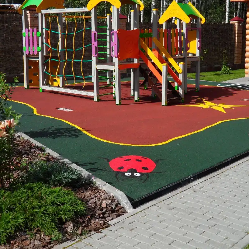EPDM playground flooring with a ladybug pattern on green and red rubber.