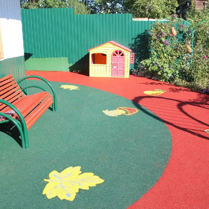 Green and red EPDM playground flooring with yellow fruit patterns.